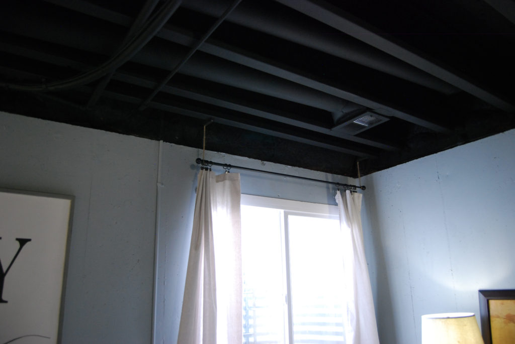 Curtain rod hung from exposed ceiling